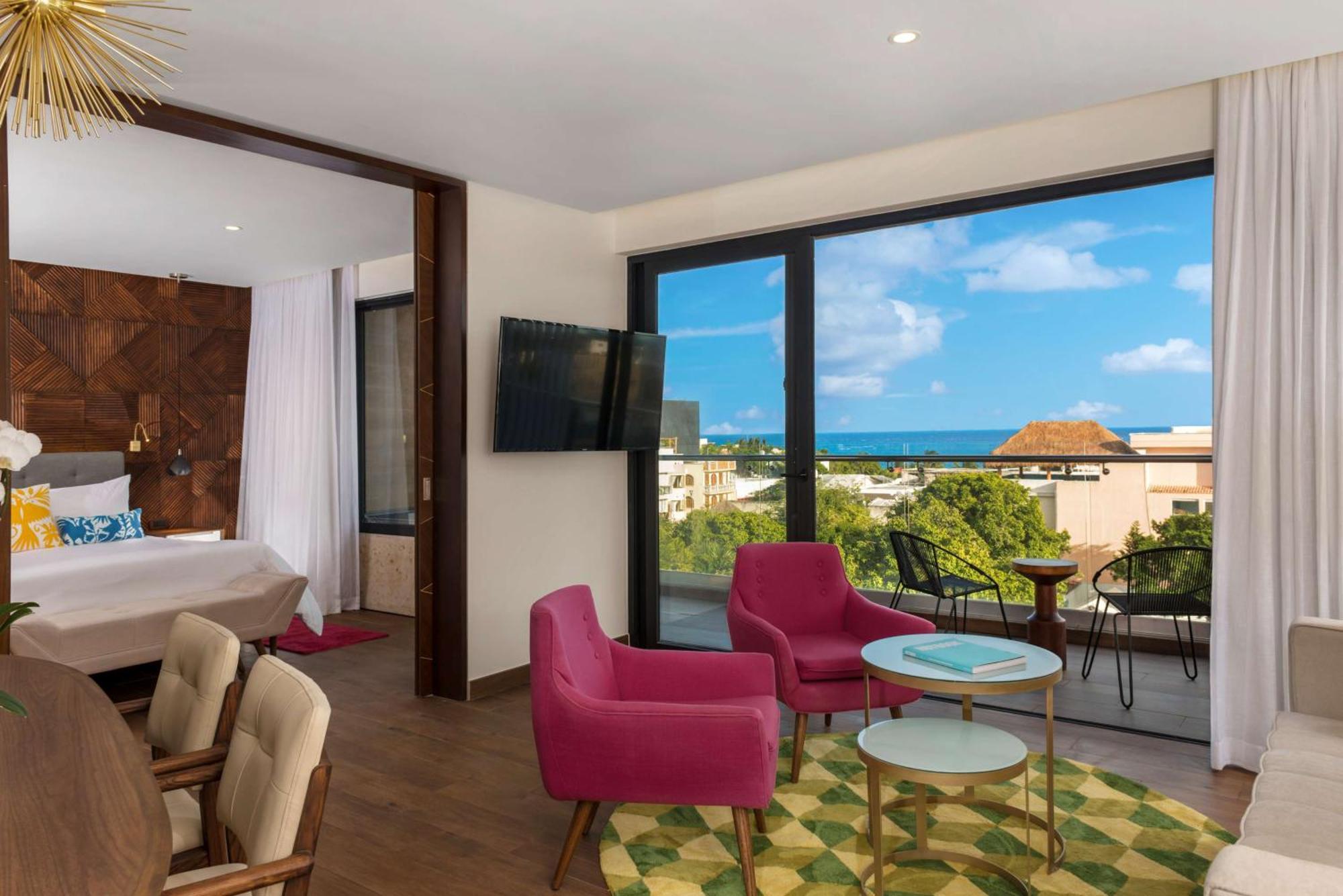 Suite de 1 dormitorio con cama grande y vistas parciales al océano